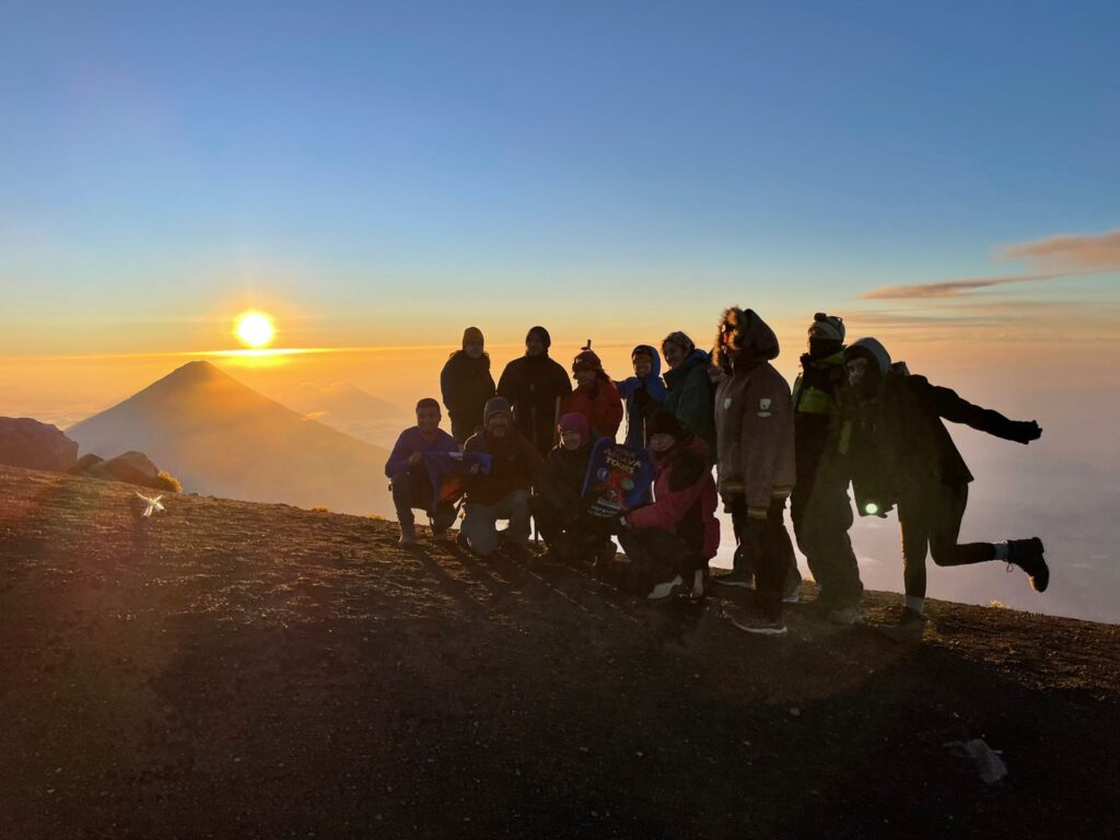 Cima del volcán Acatenango con el volcán de Fuego en erupción