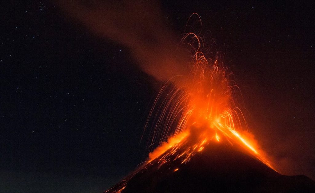 Spectacular night view of a volcano erupting in Antigua Guatemala, showcasing natural power.